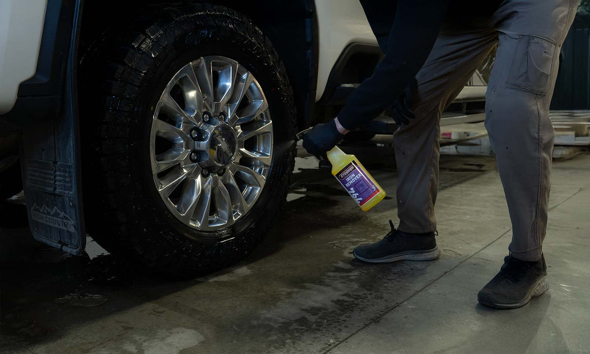 Spraying Iron Remover on truck wheel in a shop setting
