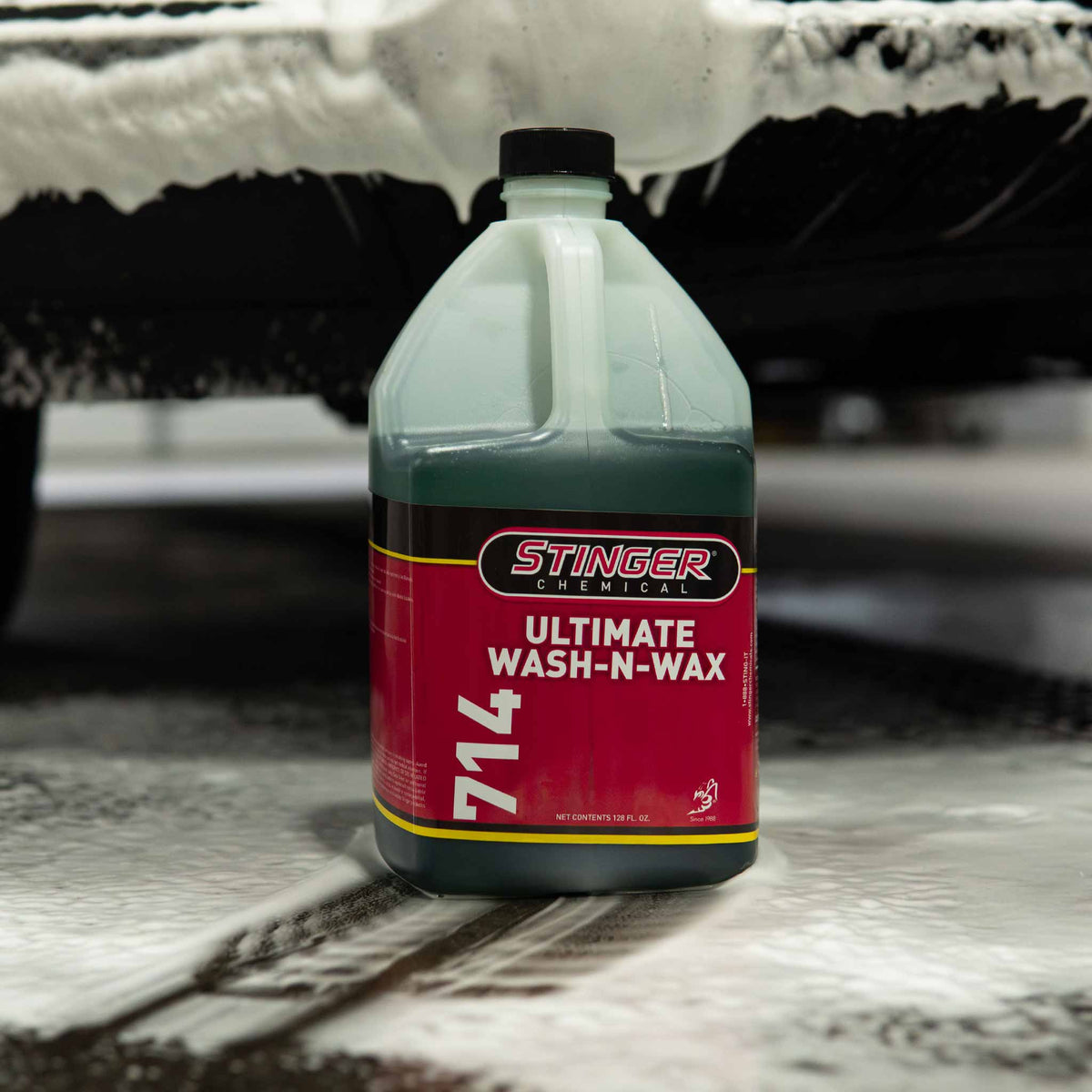 Stinger Chemical Ultimate Wash-N-Wax 714 gallon jug beside a vehicle covered in thick suds
