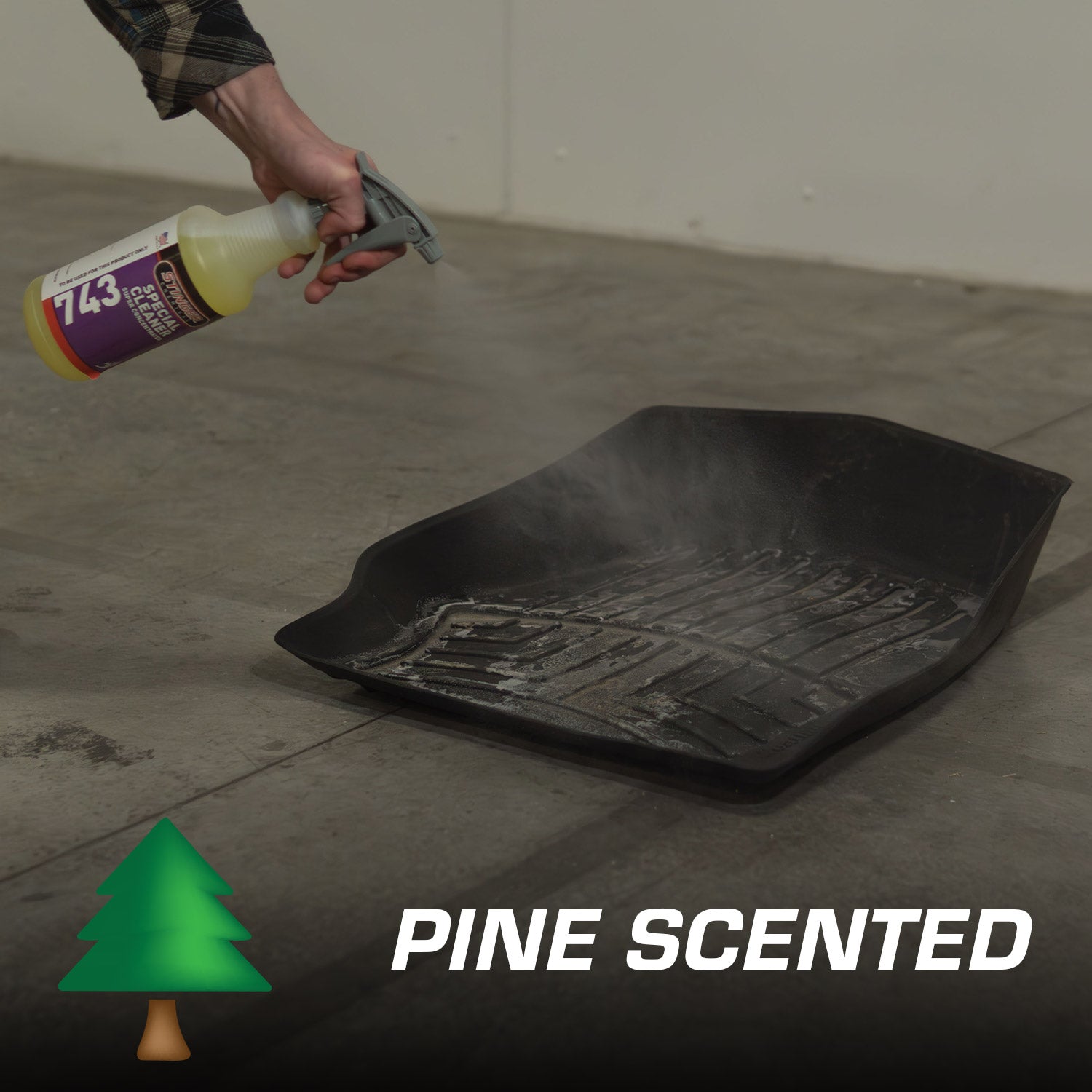 Person using a spray bottle on a black plastic floor mat with 'Pine Scented' text and logo.