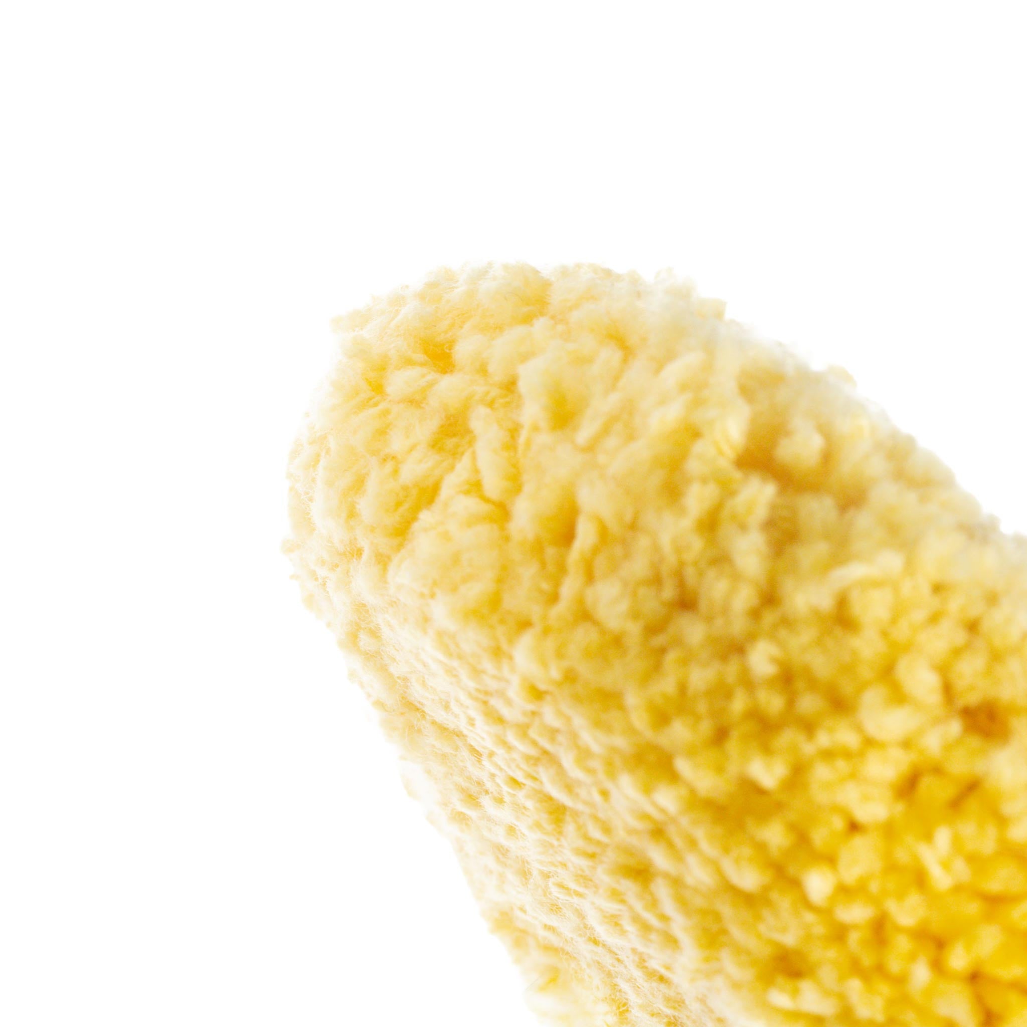 Close-up of a yellow buffing pad on a white background