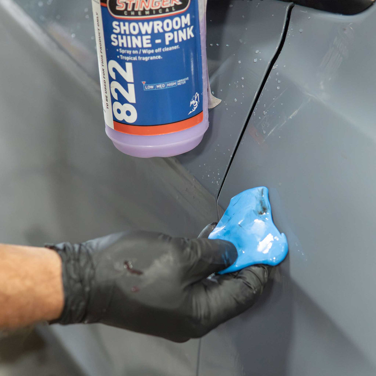 Stinger Chemical Showroom shine in the background of a dirty blue clay bar