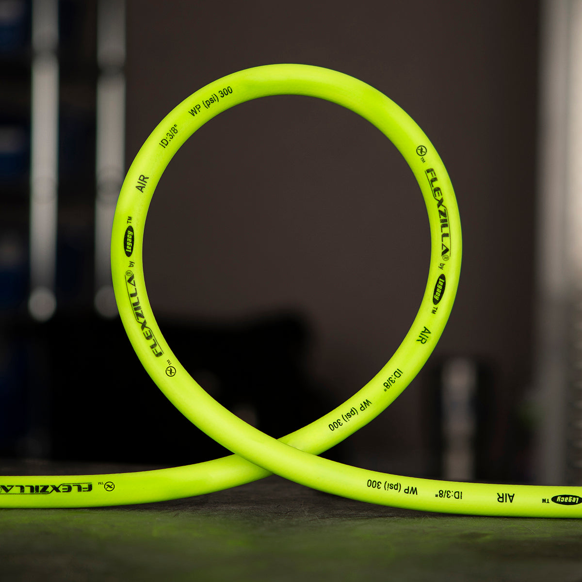 Lime green air hose in a loop with Flexzilla branding on a dark background