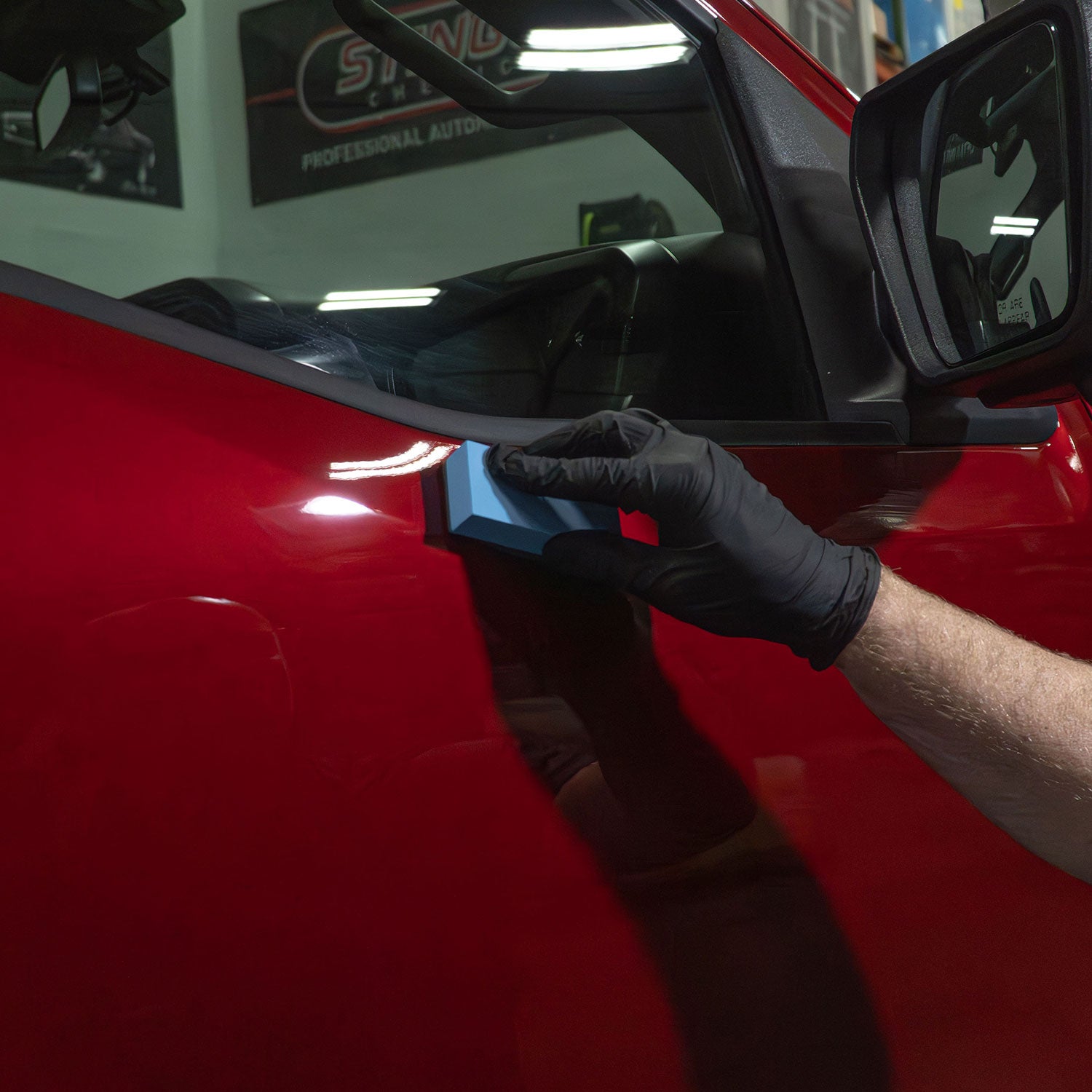 Ceramic coating applicator used to apply coating on a red ford truck