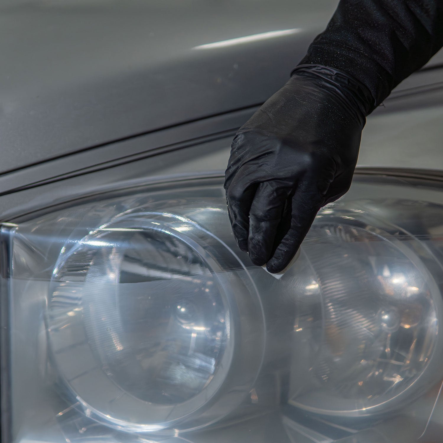 headlight restoration coating being laid down on a sanded truck headlight
