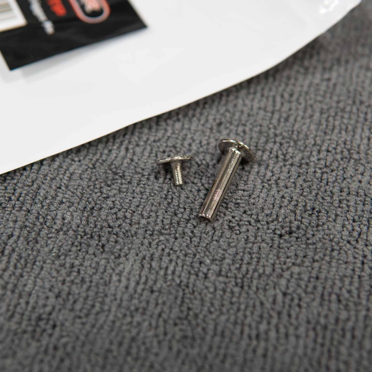Stinger Twister trigger pin sleeve and matching screw laid out beside the bag