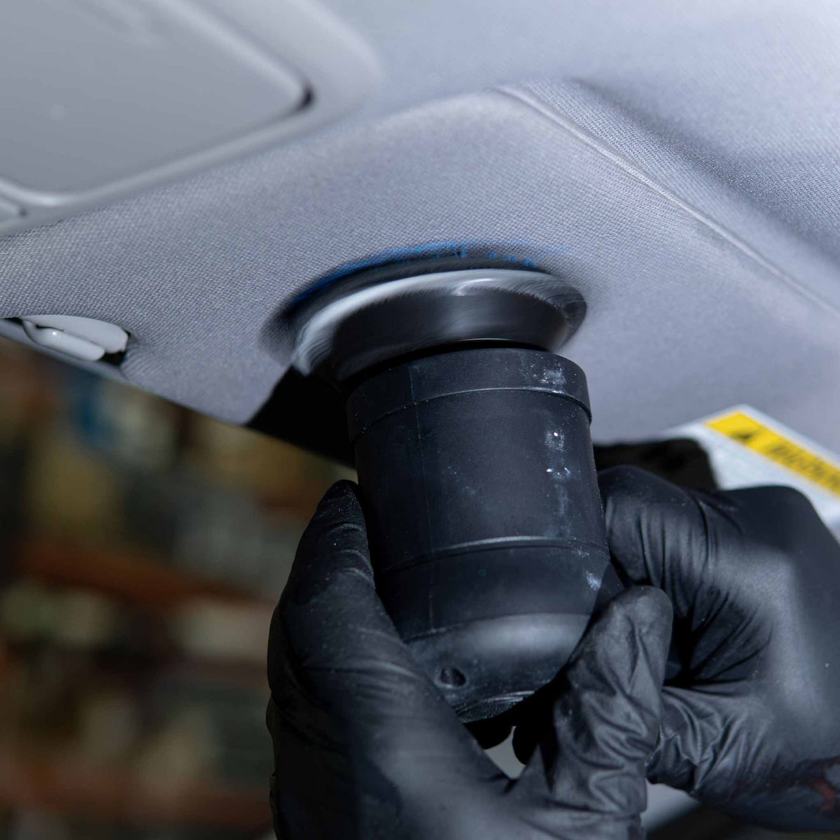 Autofiber UFO microfiber pad on a polisher cleaning a gray fabric car headliner