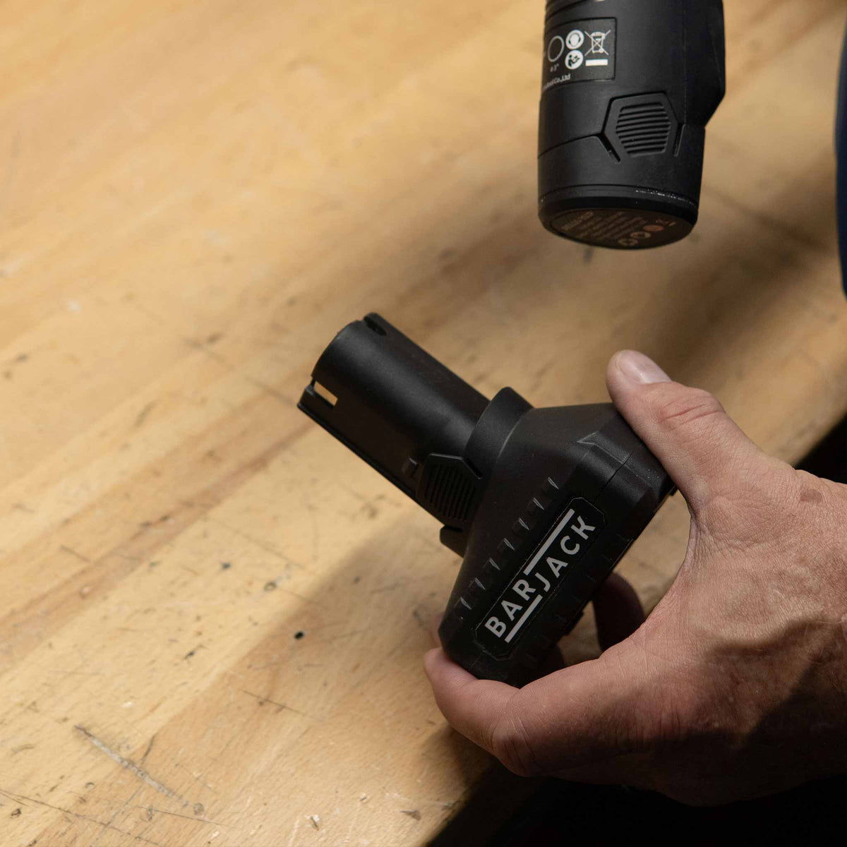 Holding the Barjack 5Ah battery under the Raven polisher handle on a workbench
