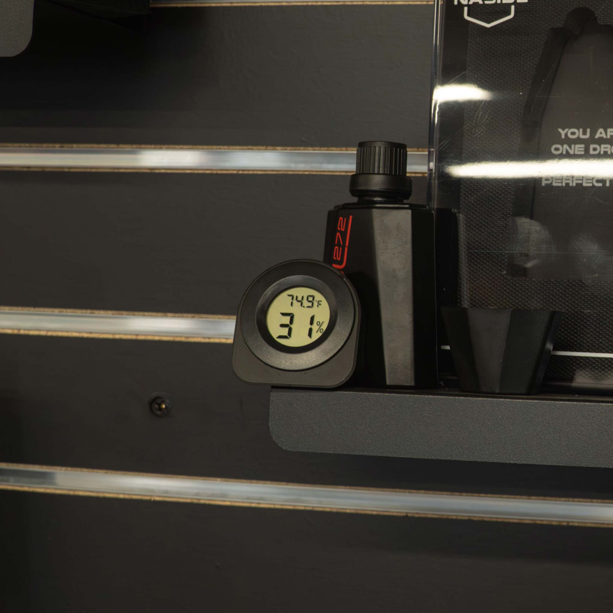 Black hygrometer in an office setting reading temperature and humidity