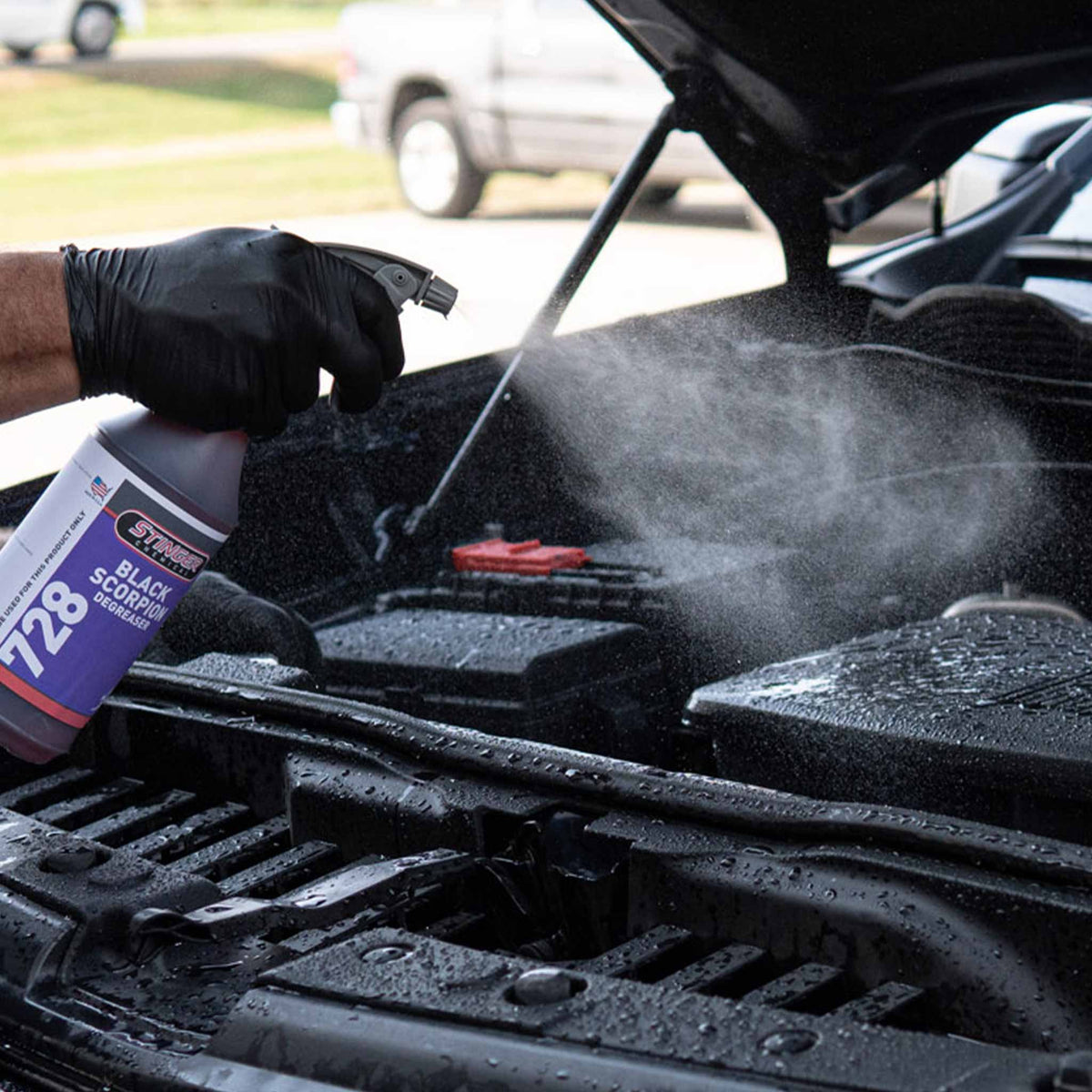 Gray maxi spray head demonstration on a car's engine bay