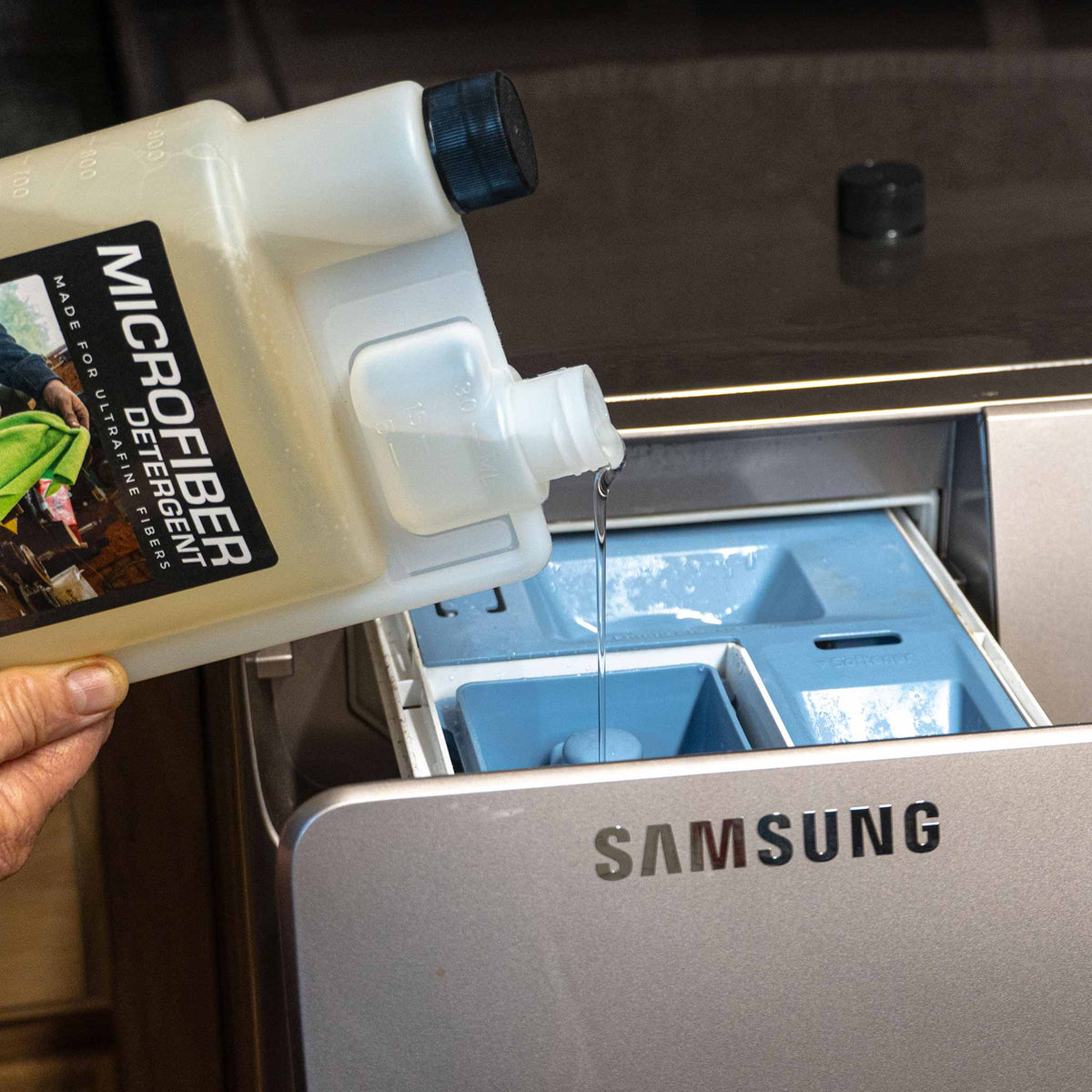 Microfiber detergent being poured into a samsung washing machine in a laundry room setting