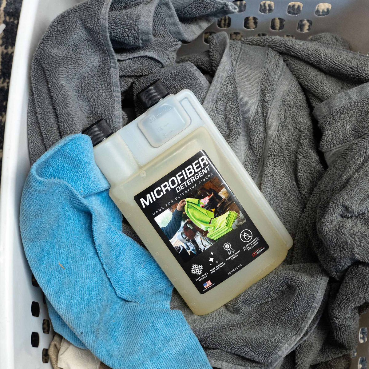 Bottle of microfiber laundry detergent in a basket of microfiber towels