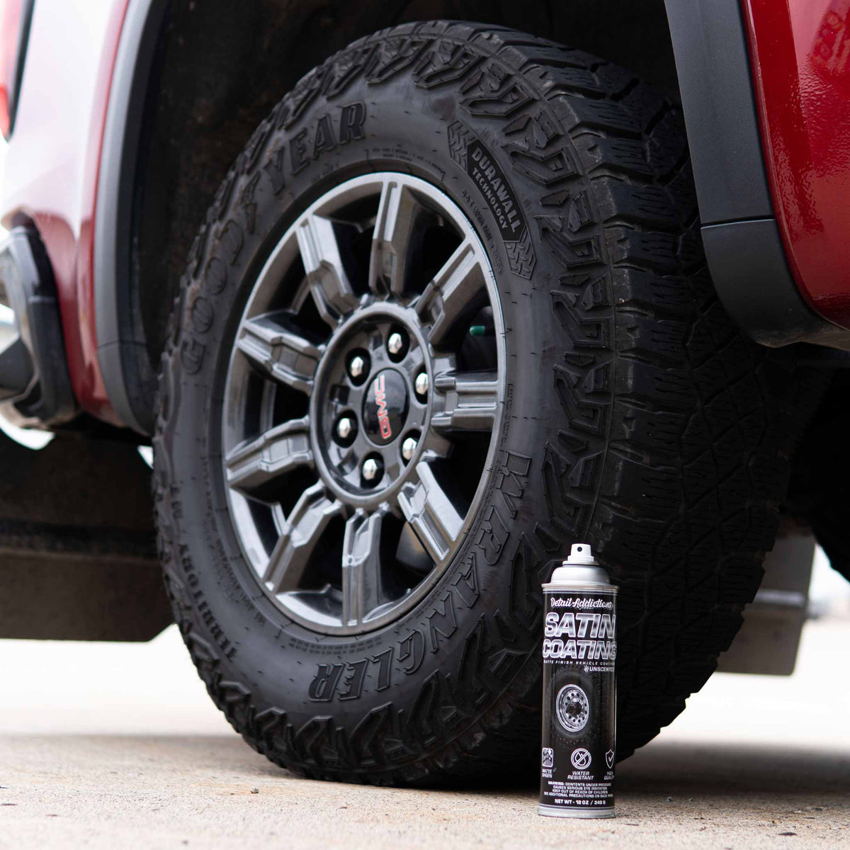 Detail Addictions Premium Satin Coating can in front of a matte black all-terrain truck tire