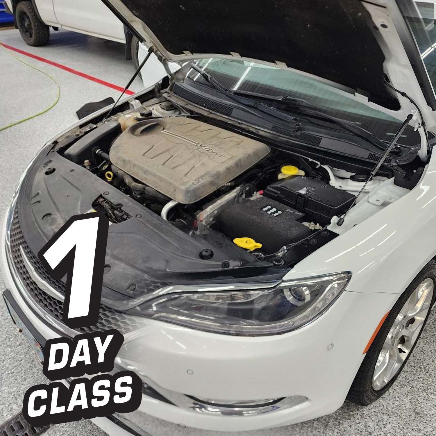 Car with open hood on a concrete surface, with text '1 DAY CLASS' overlayed.