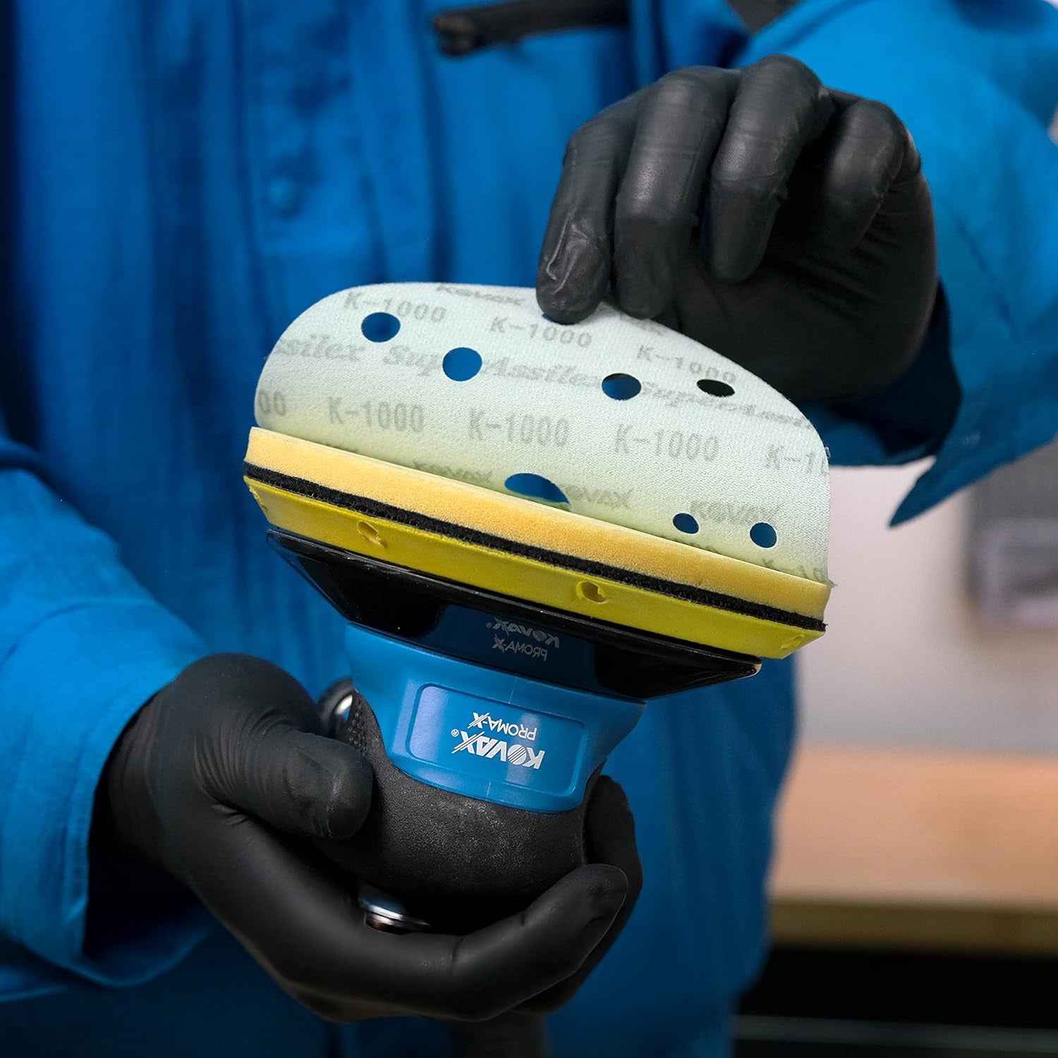 Person wearing gloves removing a sanding disc from a kovax sander