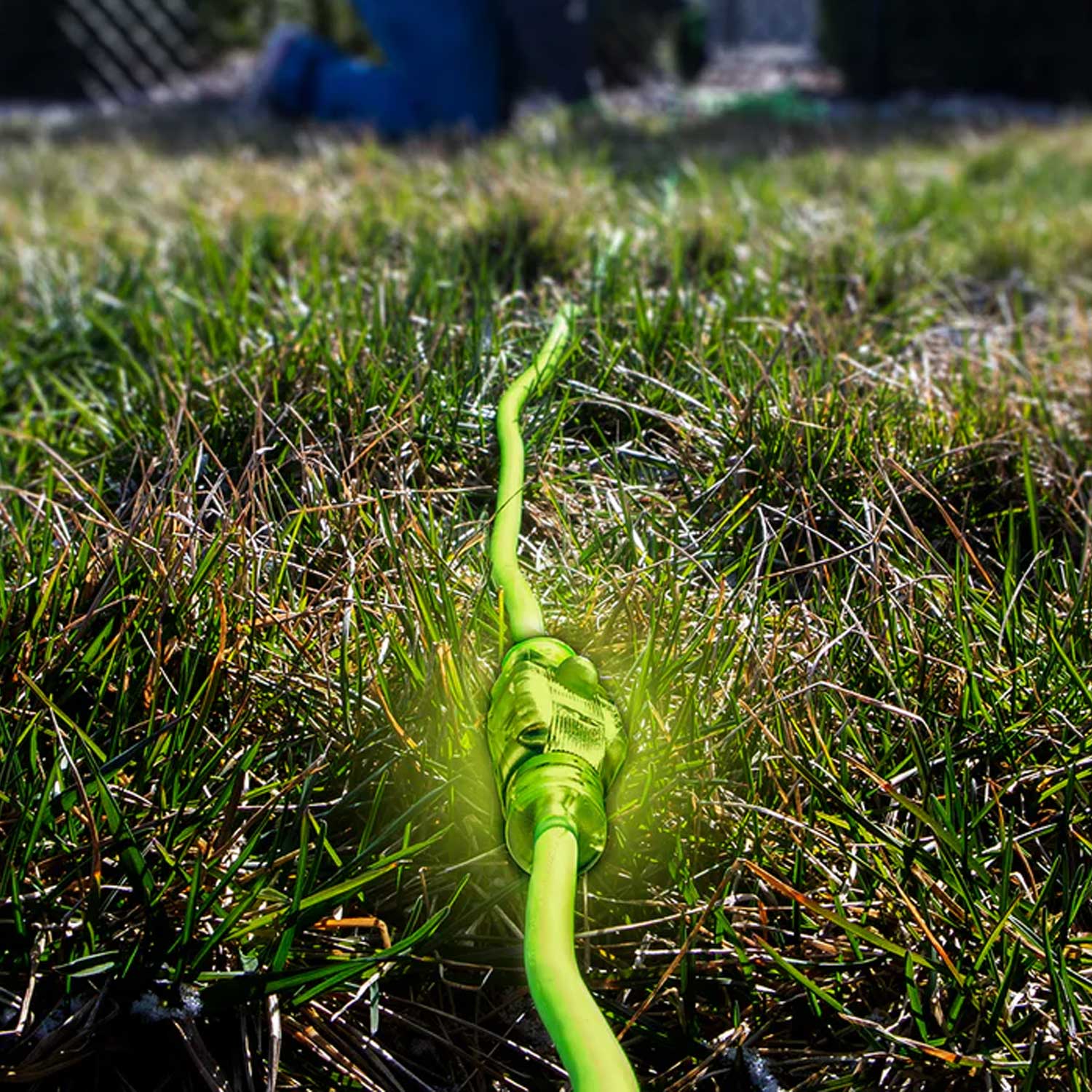 Green extension cord lying on grass