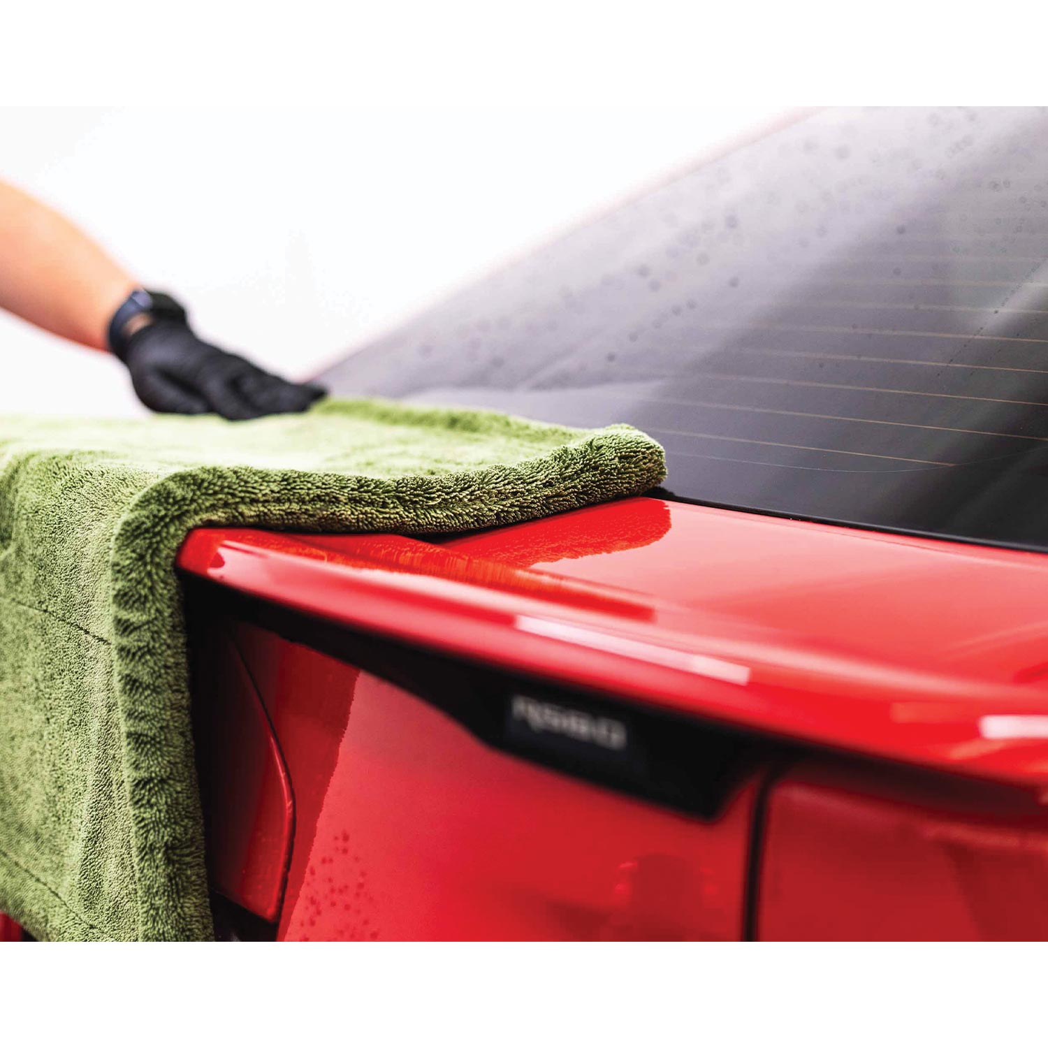 Person cleaning a red car with a liquid8r M22 towel