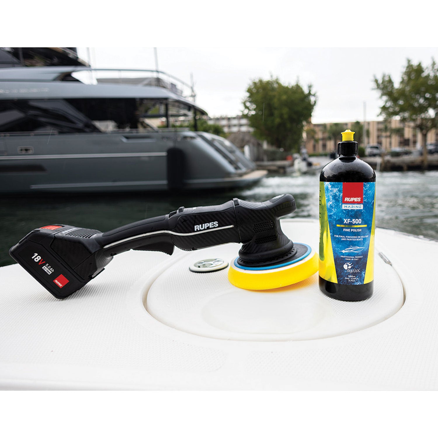 Dual Action Polisher and Rupes XF-500 on a boat with a marina background