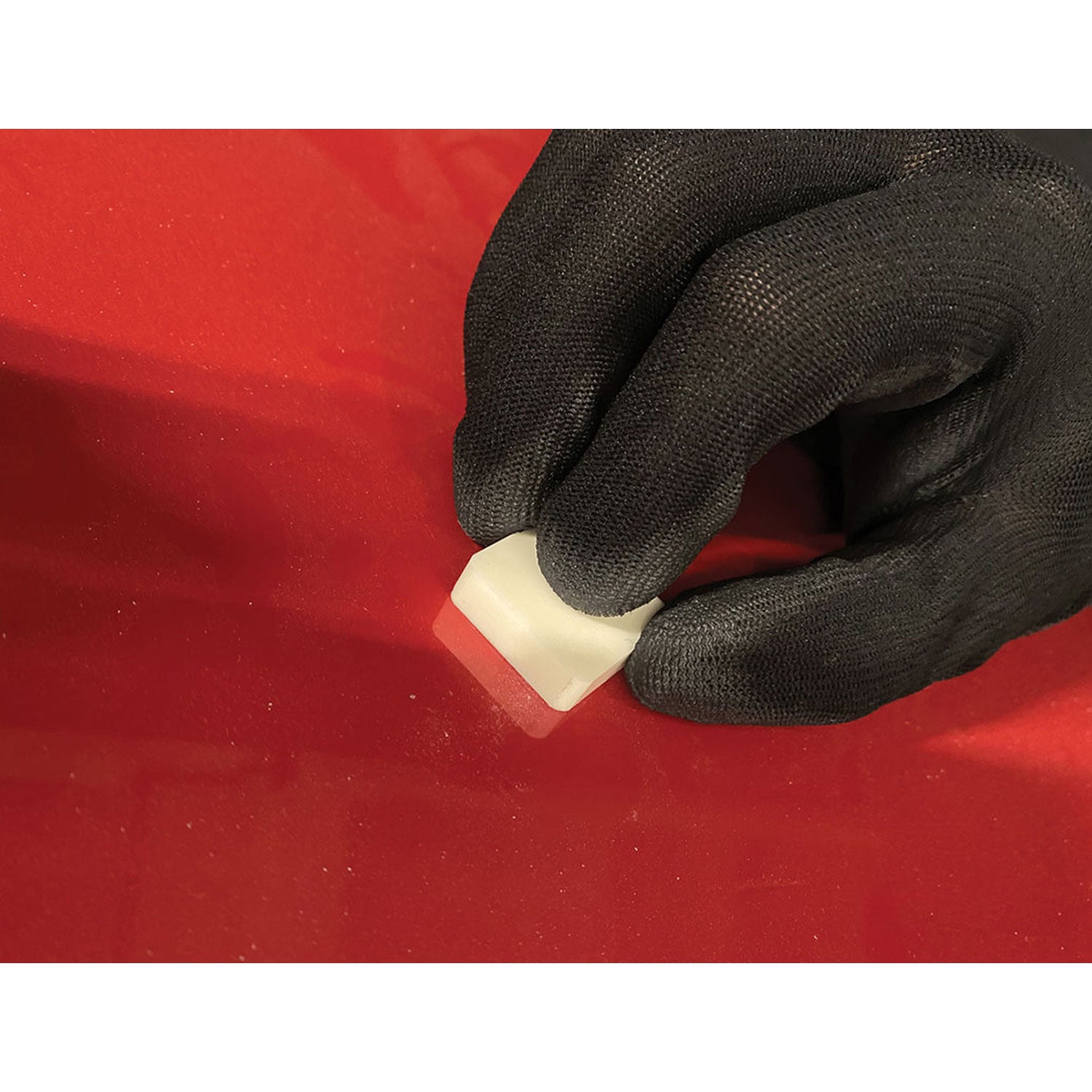 White ceramic square denibbing blade on a red car