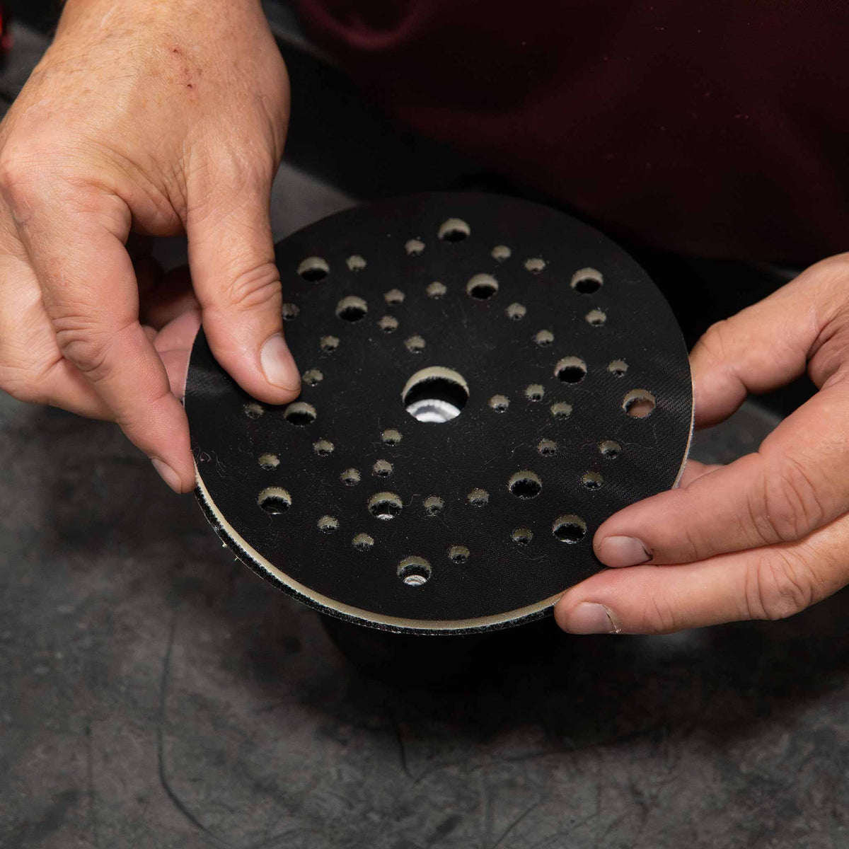 Pressing a RUPES multi hole interface pad onto a sander backing plate