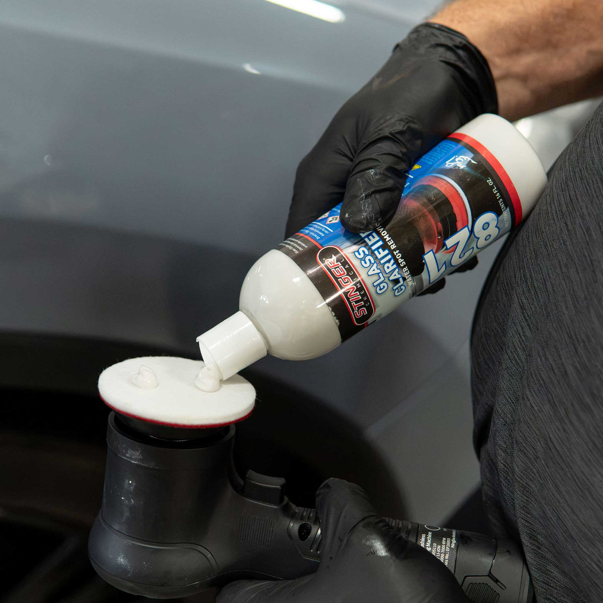 Applying Stinger 821 Glass Clarifier water spot remover to a rayon glass polishing pad
