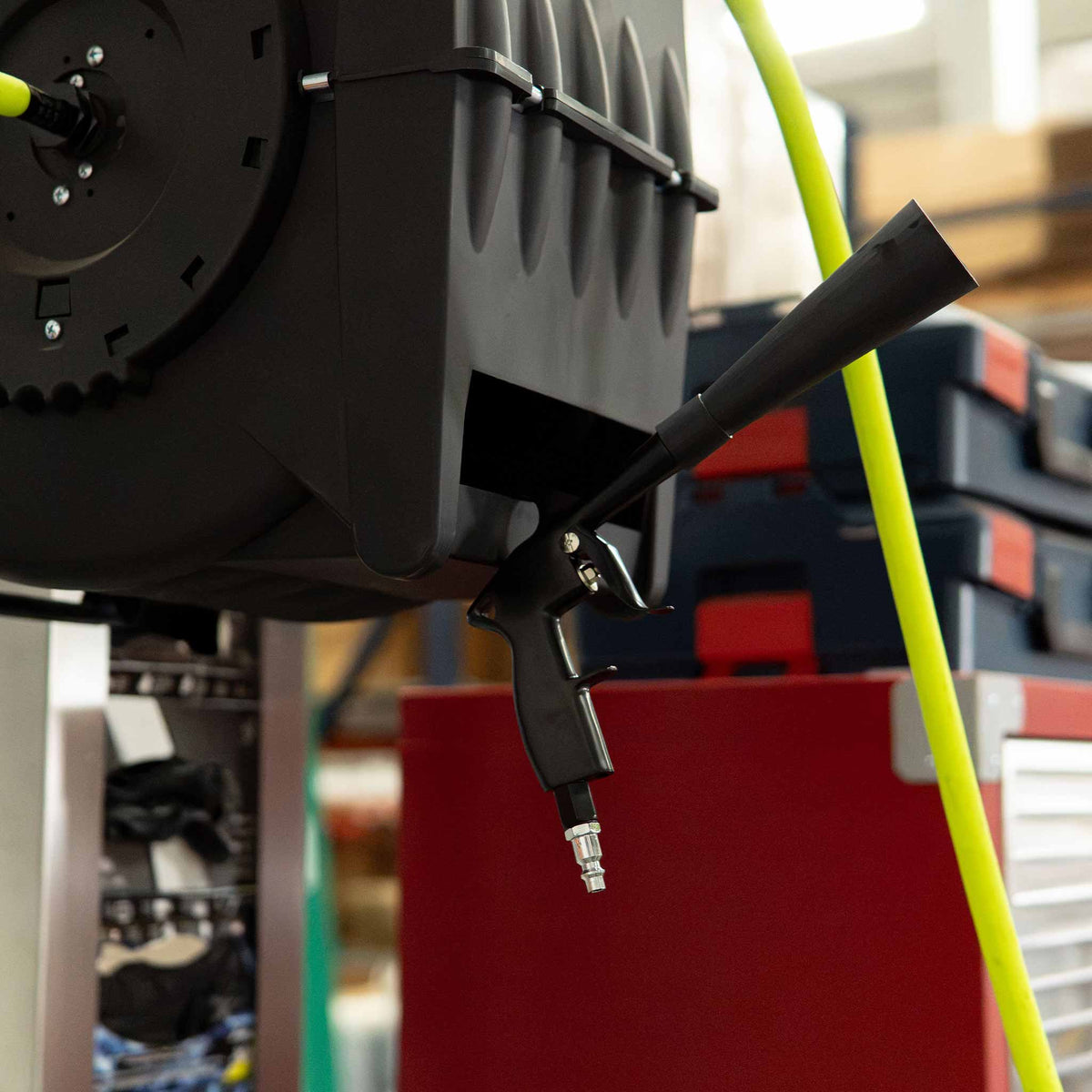 Stinger Twister Blow Gun hanging by a shop air hose reel with the cone nozzle attached