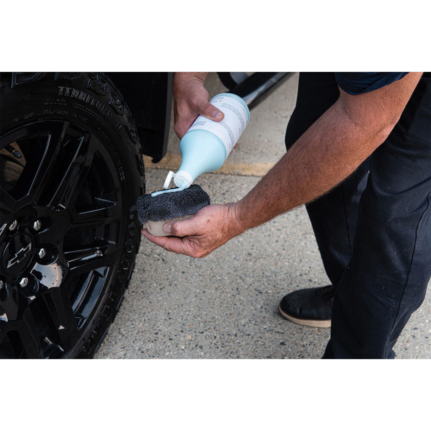 Person applying a product to a car wheel using a applicator