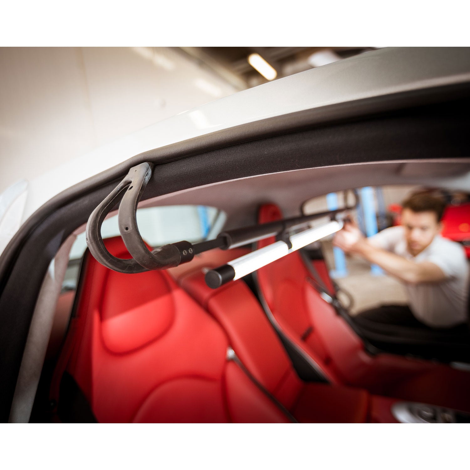 Car interior with a lighting tool hanging from the interior roof, blurred background