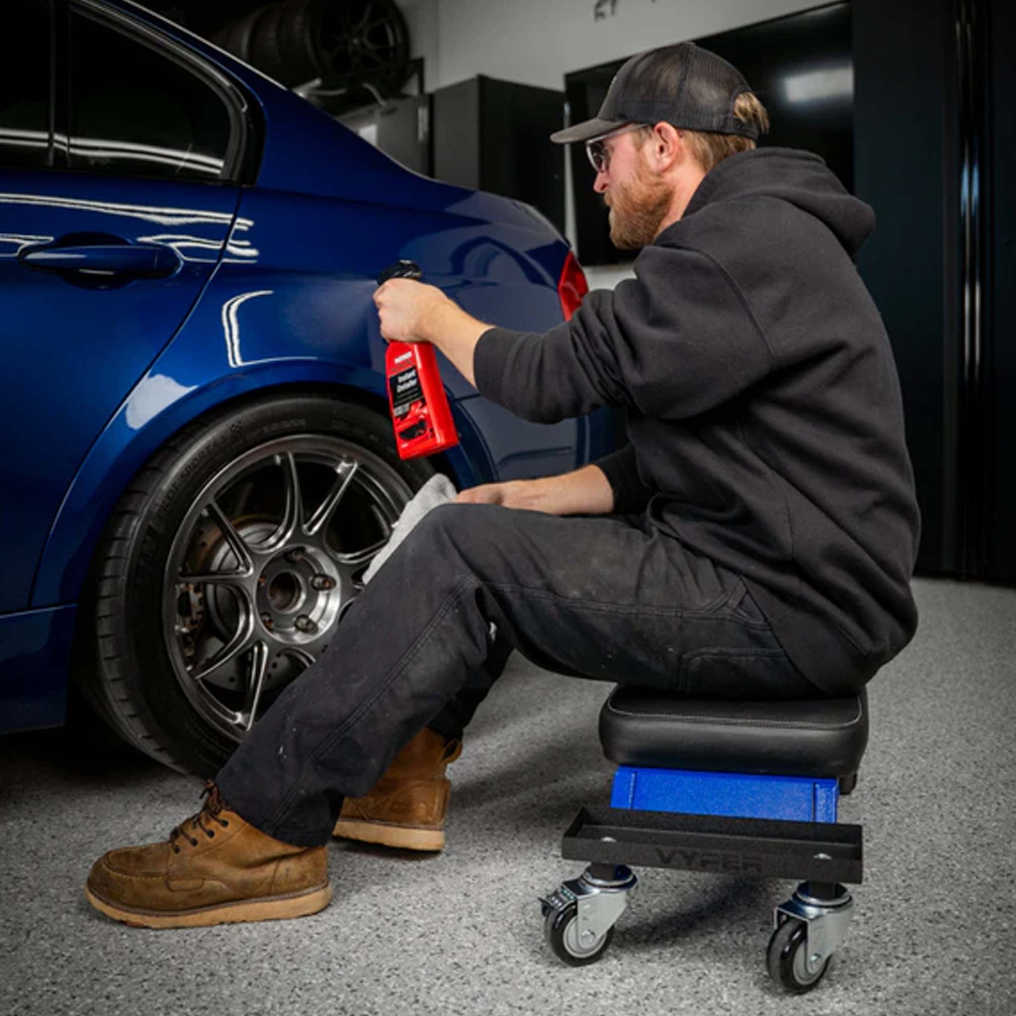vyper mini creeper used in a detailing garage with blue legs