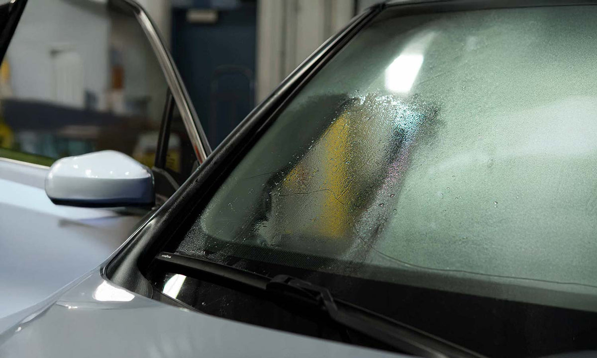 Clear Water Spot Remover on a windshield with water sprayed on it