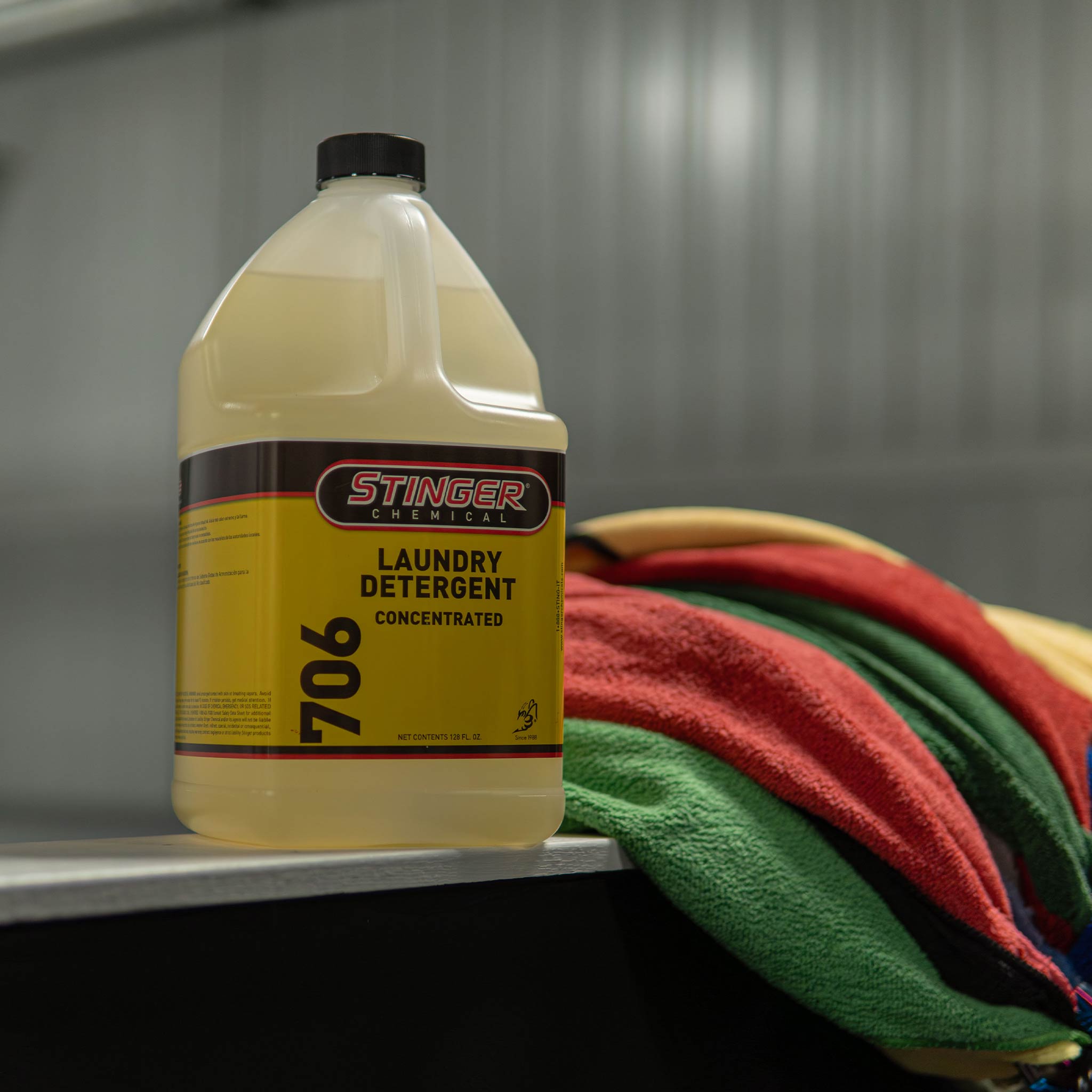 stinger chemical laundry detergent concentrated on a ledge with towels in the background