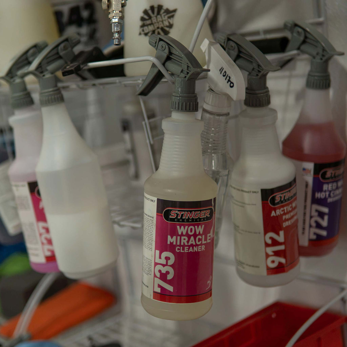 Stinger Chemical Wow Miracle Cleaner 735 spray bottle hanging on a shop rack with other Stinger detailing chemicals