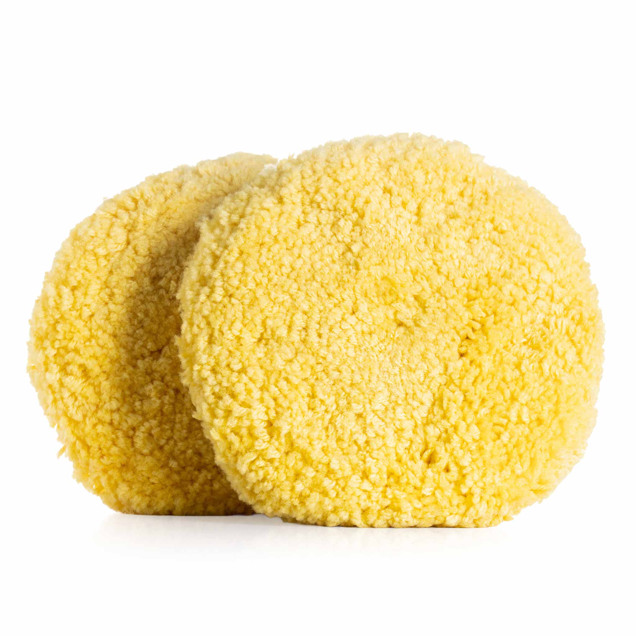 Two yellow wool pads on a white background