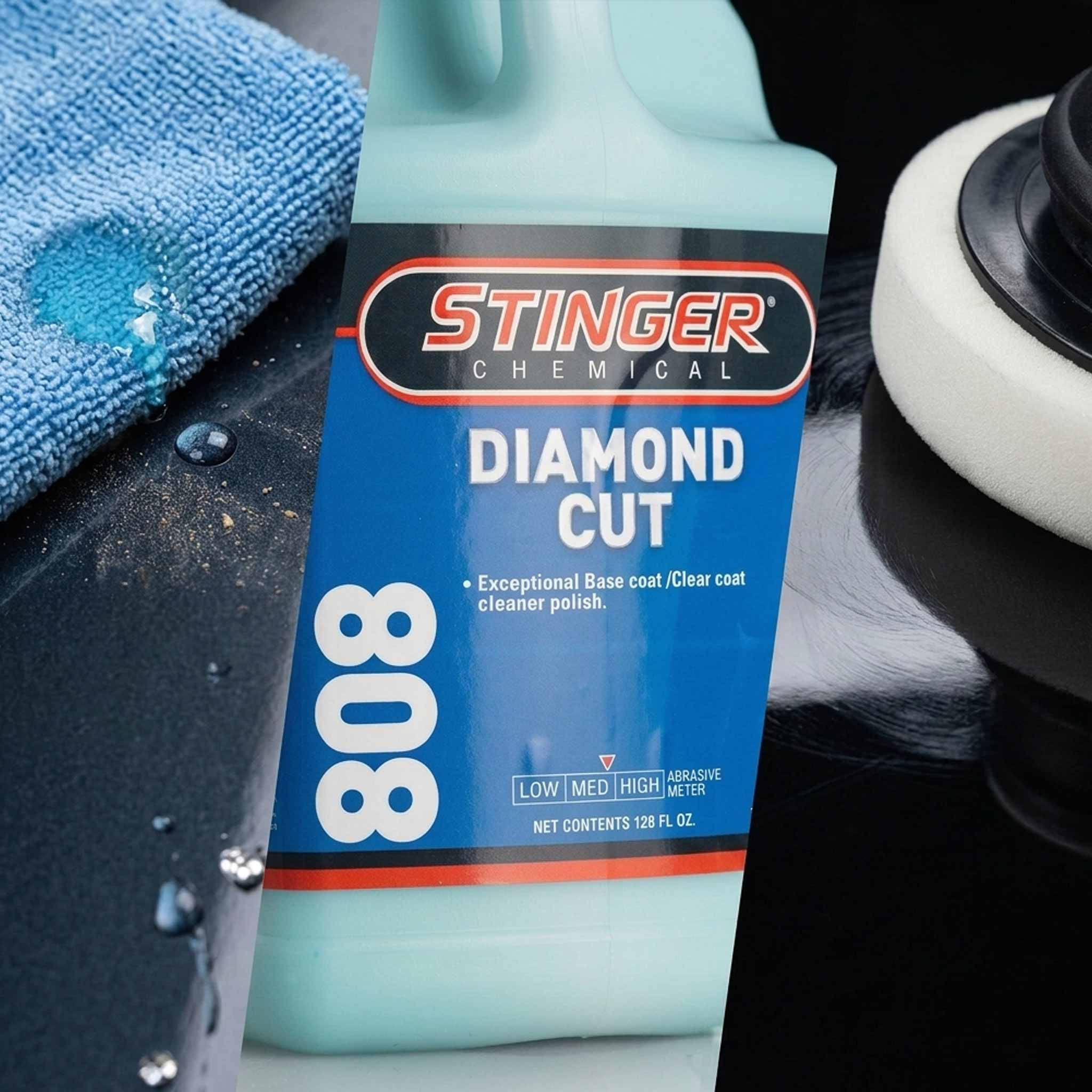 Stinger Diamond Cut 808 car polish bottle on a car surface with a blue towel and white buffing pad