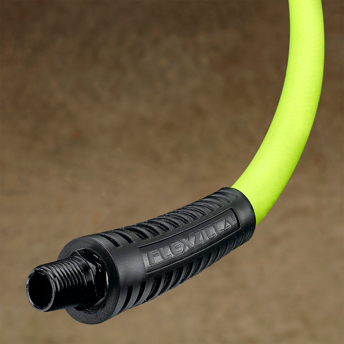 Close-up of a lime green air hose connector on a brown background
