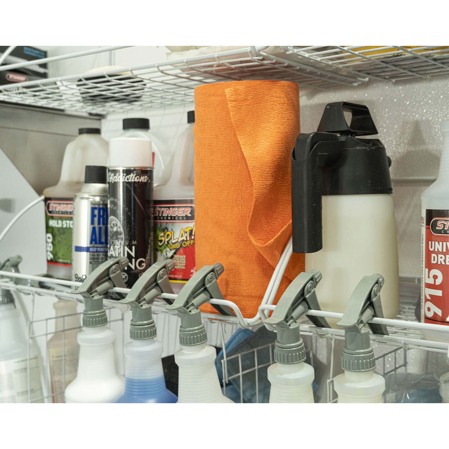 Shelf with cleaning supplies including bottles and a rolla-fiber towels