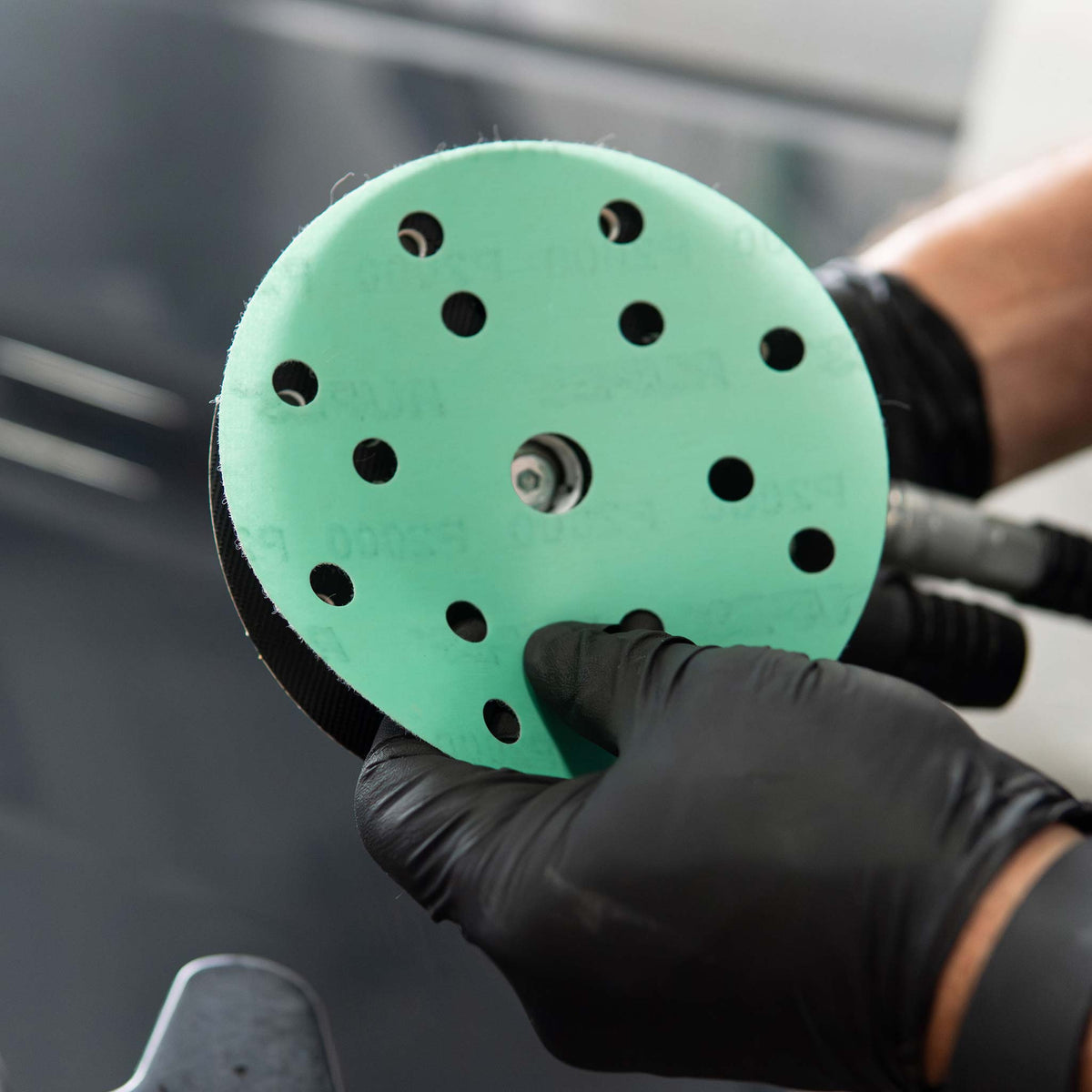 Pressing a RUPES PROCUT film disc onto the hook and loop backing pad of a sander