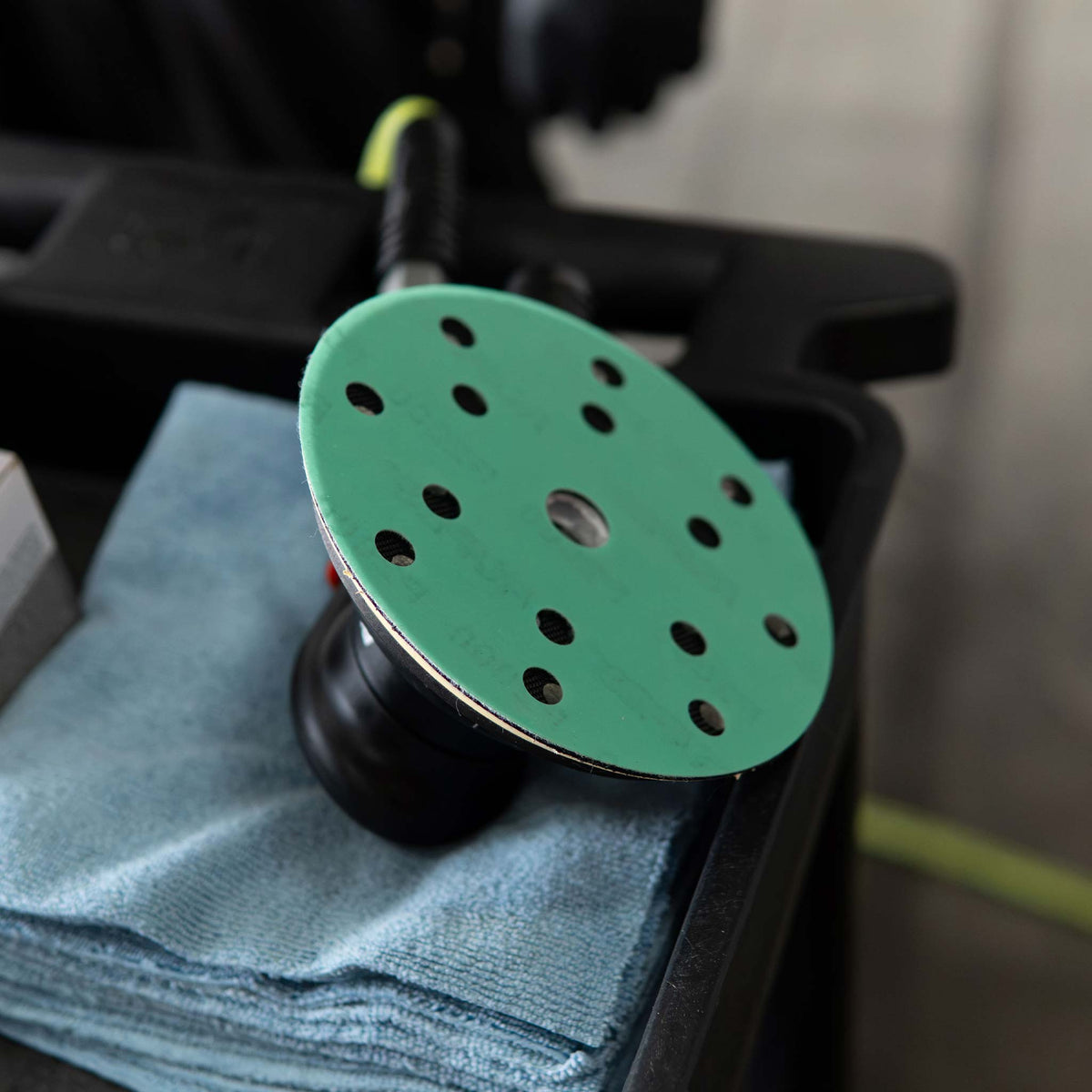 RUPES PROCUT disc fitted to a sander resting on a microfiber towel in its case