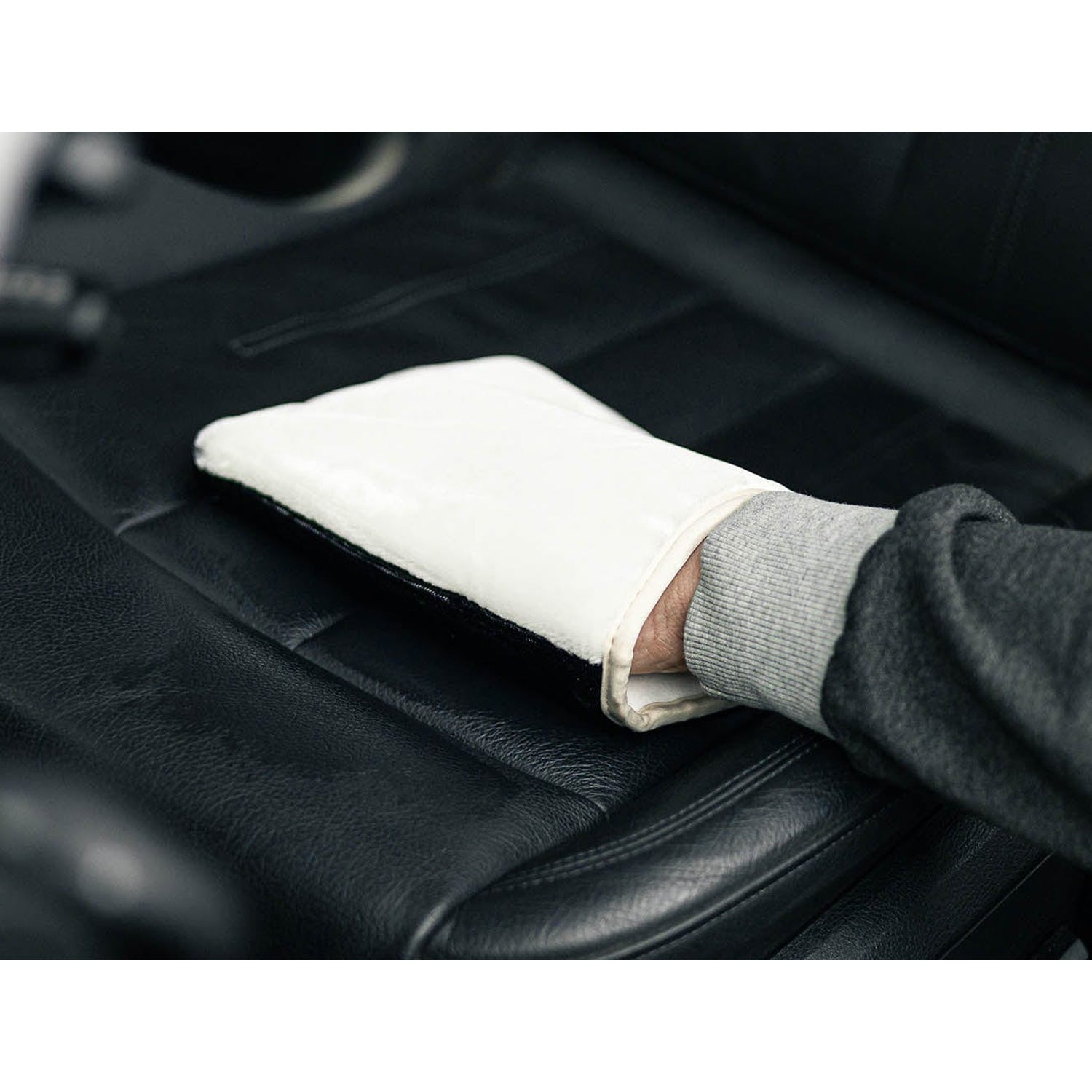 Person cleaning car interior with a white and black scrub ninja max