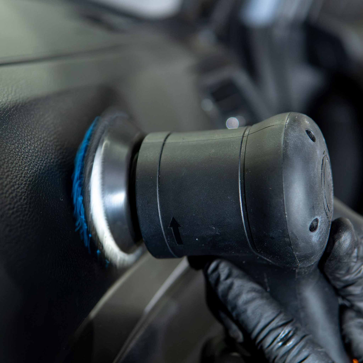 Autofiber UFO pad mounted on a polisher scrubbing a black textured dashboard