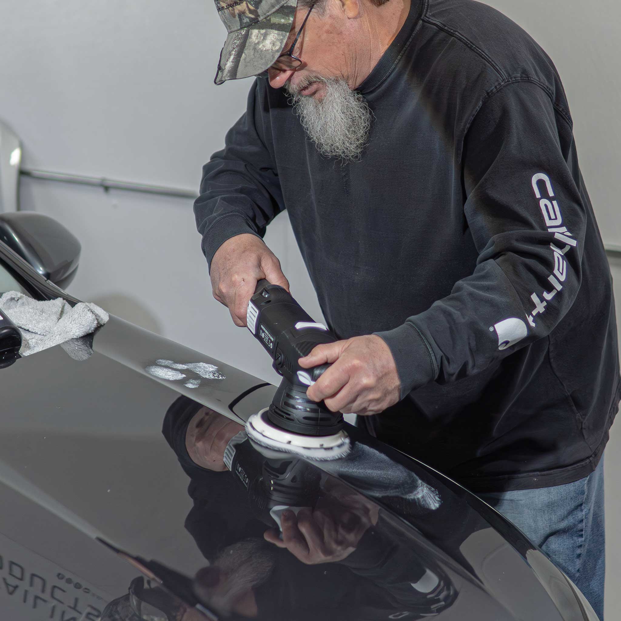 Carhart Dean using the 5" dual action barjack buffer on a silver car hood