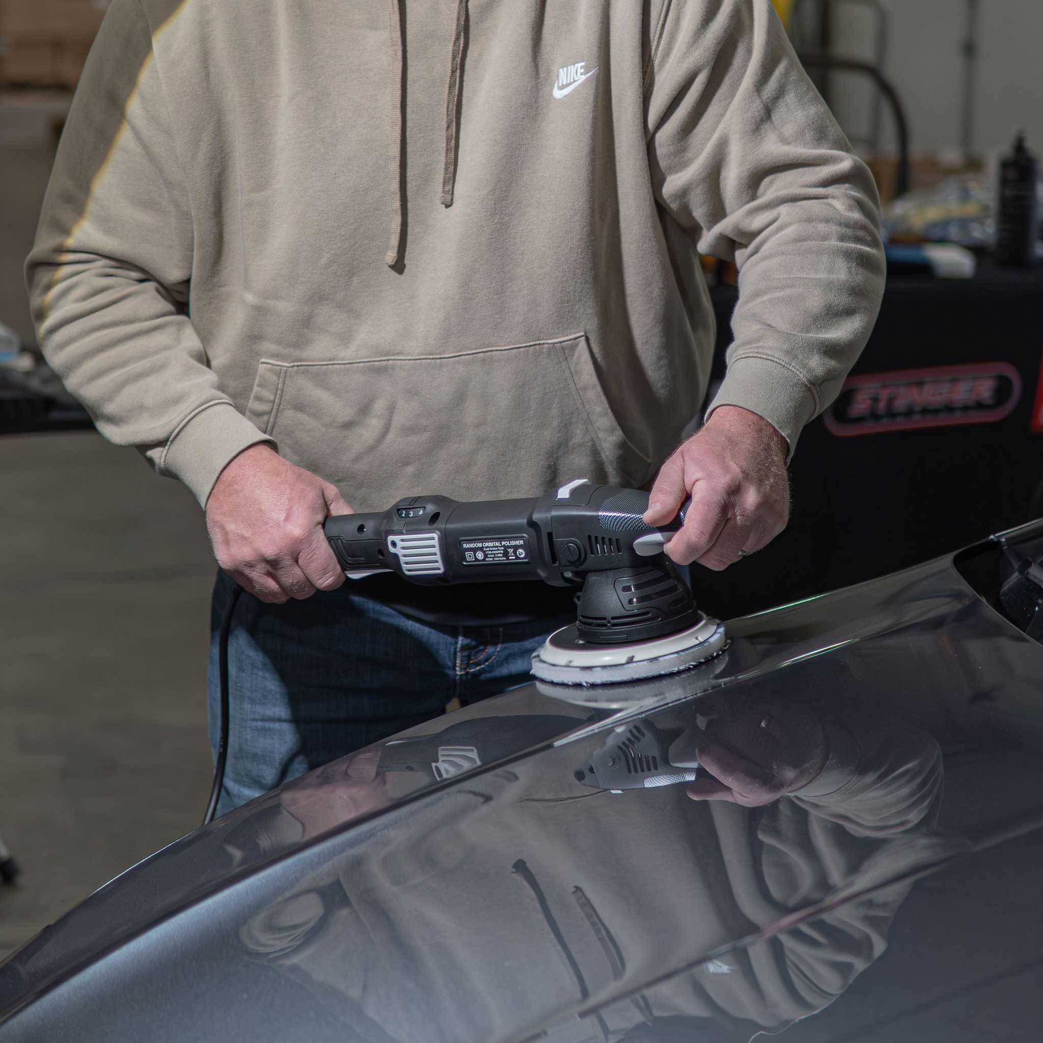 Barjack Orbital Polisher on a car hood in a shop setting