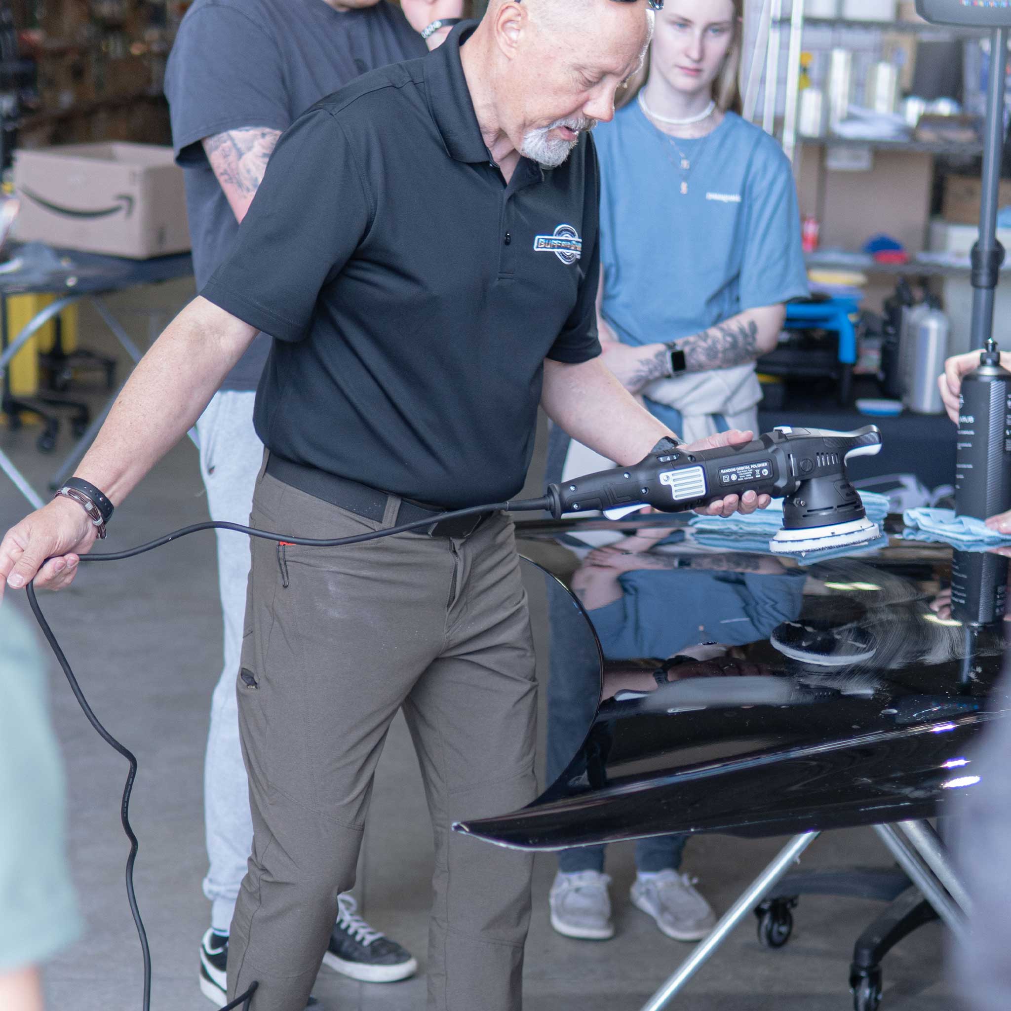 Person using a Barjack tool in a workshop setting with another person in the background.