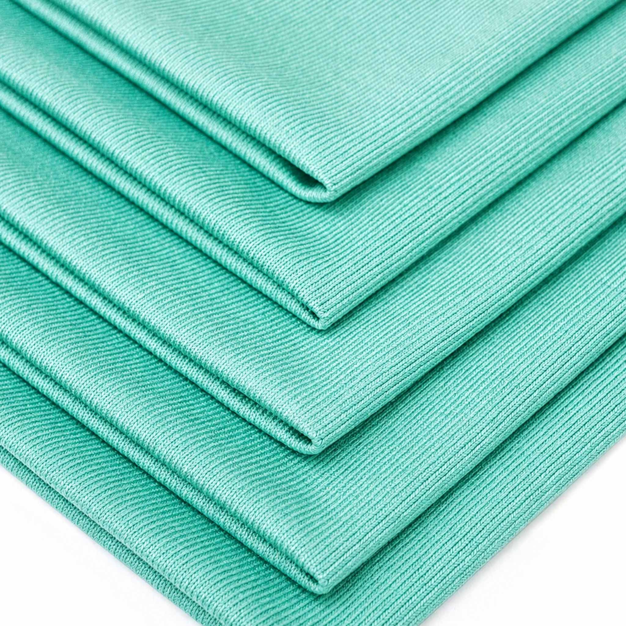 Stack of green microfiber cloths on a white background