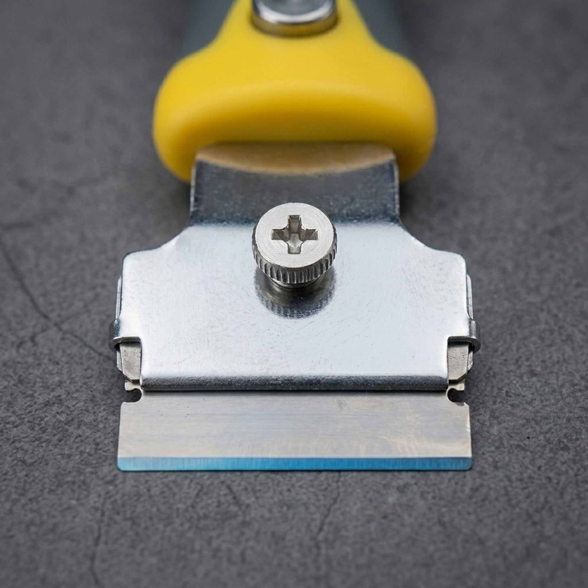Razor Blade Scraper with a yellow handle on a gray background