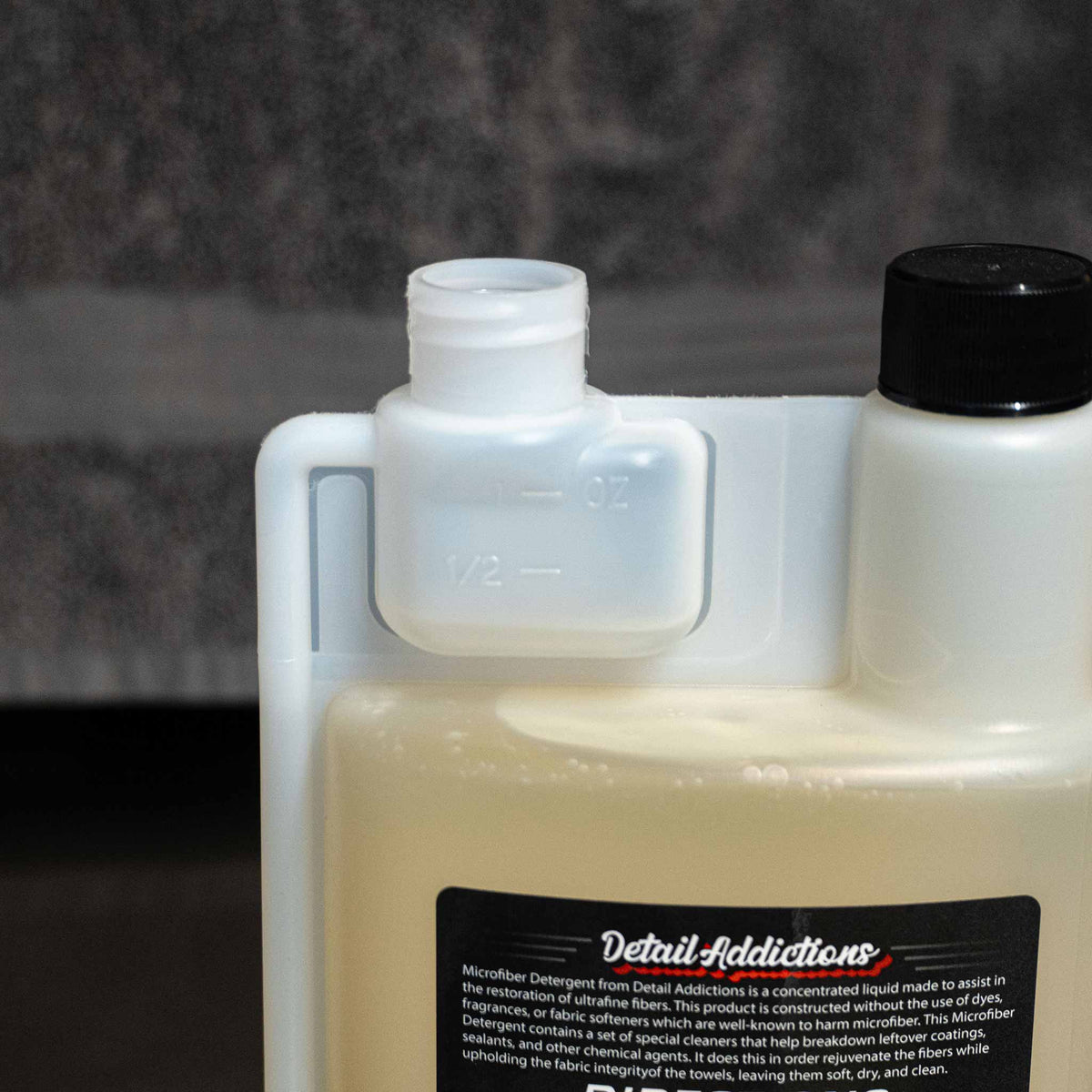 measuring cap on the bottle of microfiber detergent in a blurred out laundry room setting