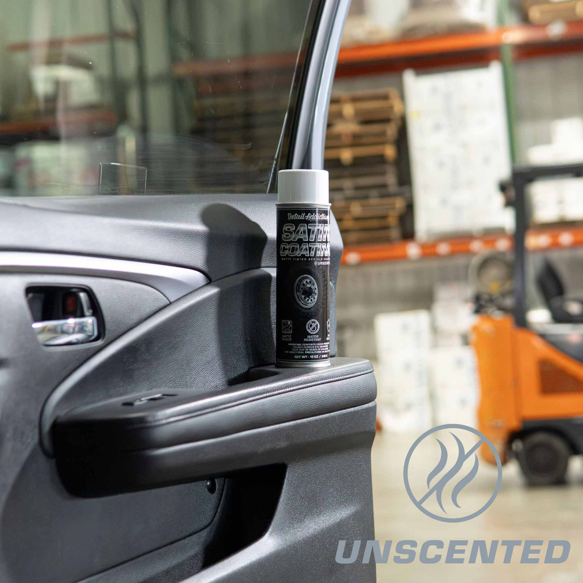 Detail Addictions Premium Satin Coating unscented dressing can on a car door armrest in a warehouse
