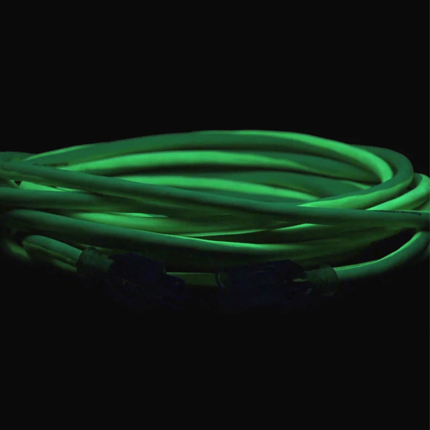 Glowing green extension cord on a black background