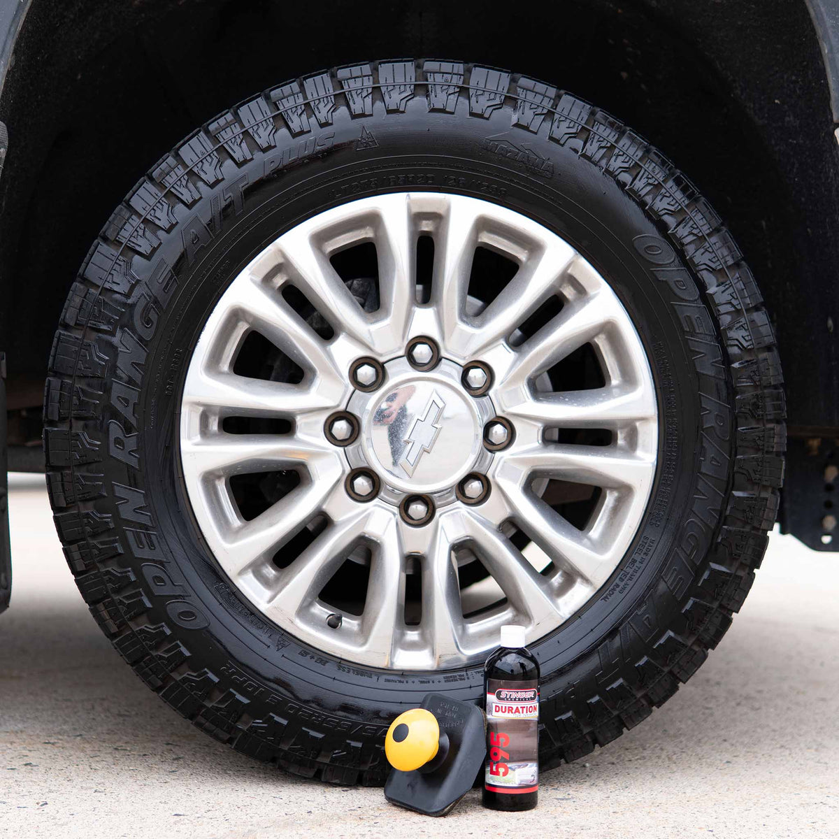Hi-Tech 2250 applicator and Stinger Duration bottle beside a dressed all-terrain truck tire