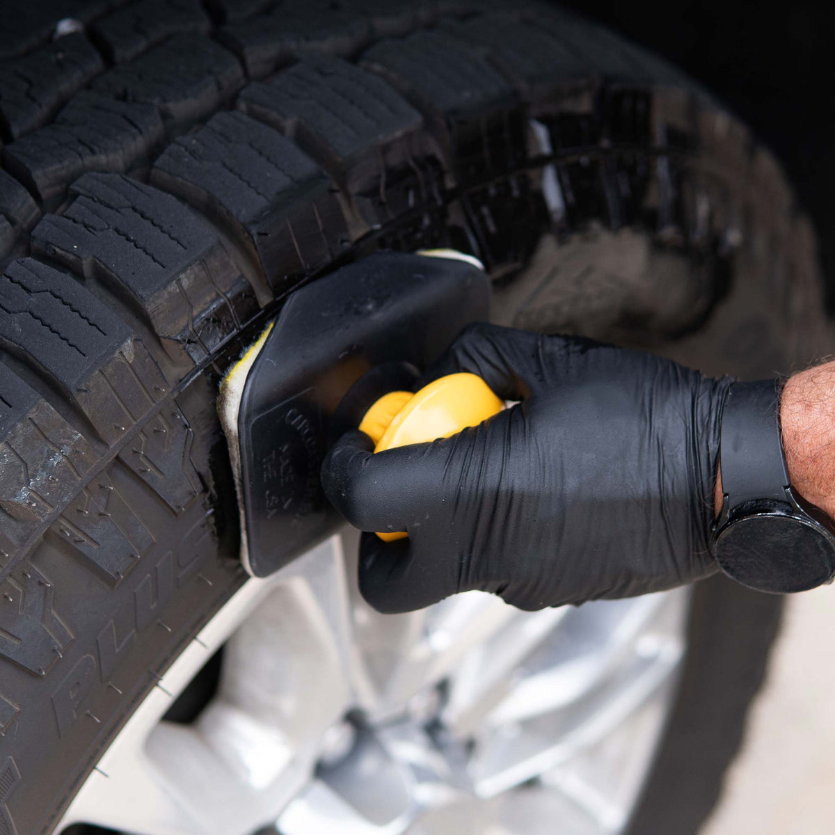 Hi-Tech 2250 swivel applicator spreading tire dressing on a truck tire sidewall