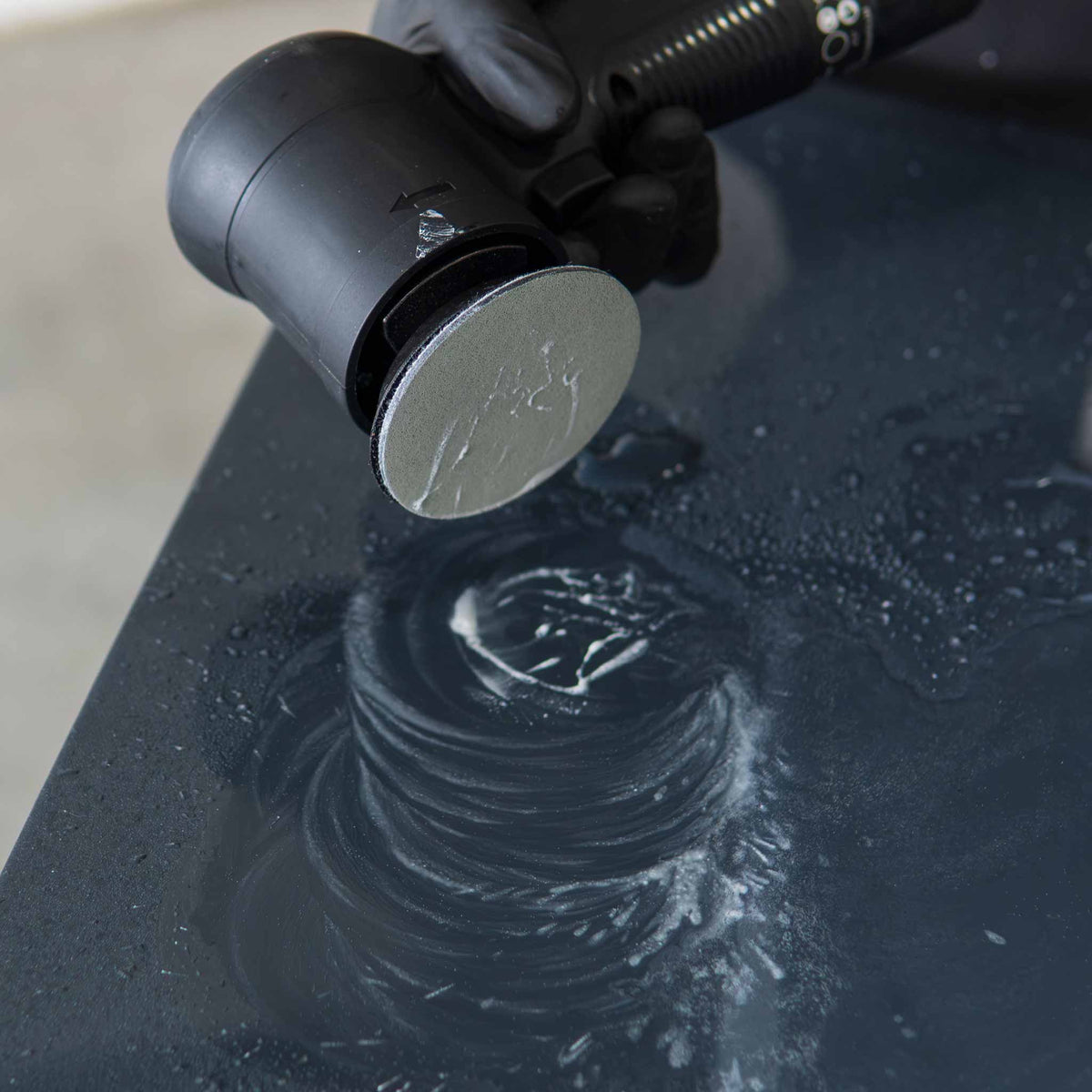 RUPES WetFinish disc lifted to show the wet sanding slurry ring on black paint
